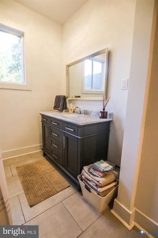 1910 W Main Street, The Historic Fan District, Richmond, VA 23220 Dark-toned vanity with a light-toned countertop, a rectangular mirror, and a single window