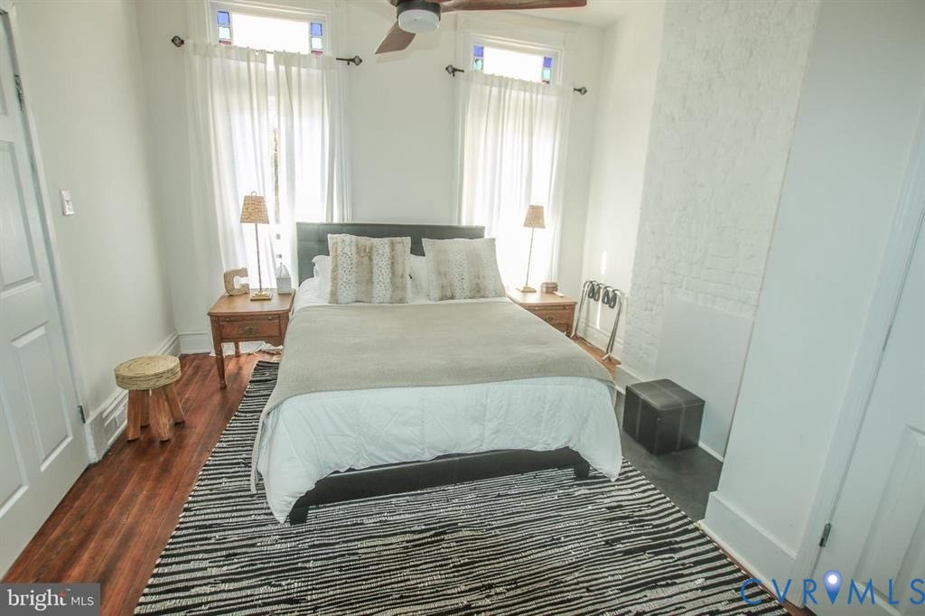 1910 W Main Street, The Historic Fan District, Richmond, VA 23220 Hardwood flooring, painted brick wall, ceiling fan with integrated lighting, and transom windows