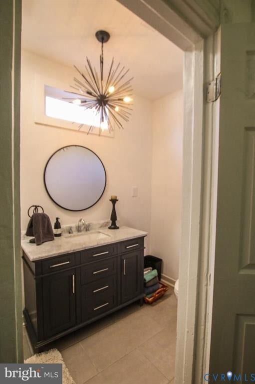 1910 W Main Street, The Historic Fan District, Richmond, VA 23220 Powder room featuring a dark wood finish vanity with a light-colored countertop, an undermount sink, a circular wall mirror, and a unique sputnik-style light fixture