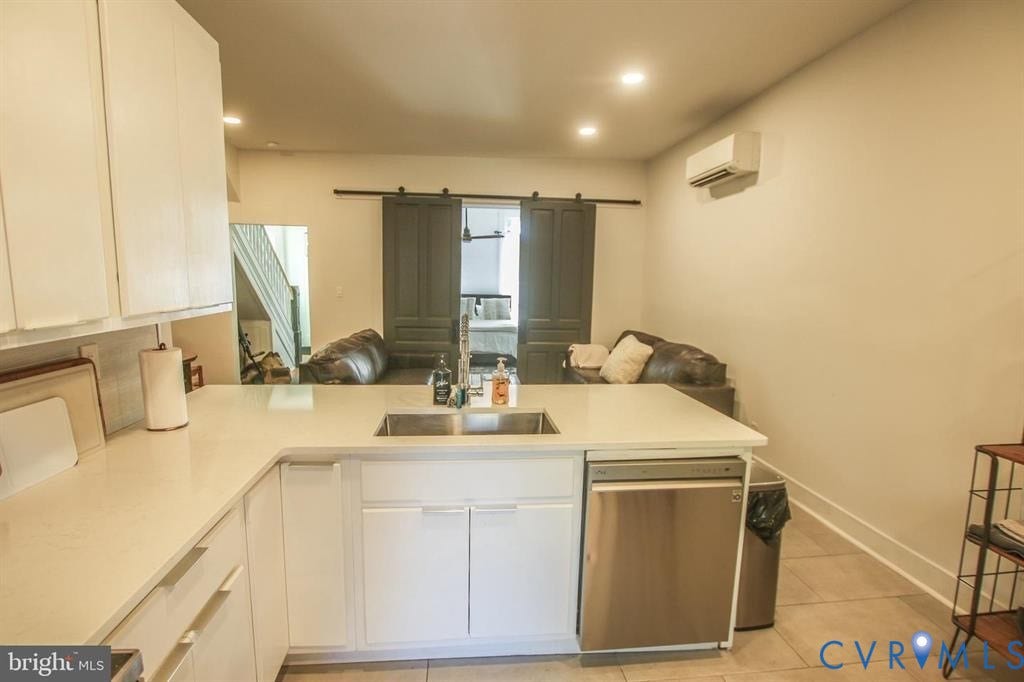 1910 W Main Street, The Historic Fan District, Richmond, VA 23220 Kitchen featuring white cabinetry, light-toned countertops, a stainless steel dishwasher, and a double basin sink