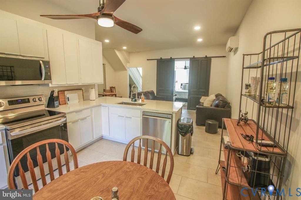 1910 W Main Street, The Historic Fan District, Richmond, VA 23220 Modern kitchen with white cabinetry, stainless steel appliances, and a central island with a sink