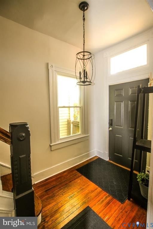 1910 W Main Street, The Historic Fan District, Richmond, VA 23220 Rich wood-finish flooring, dark paneled entry door, and a decorative pendant light fixture