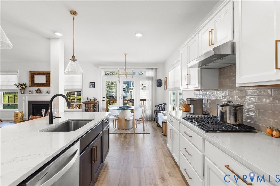 12906 Craftsbury Court, Midlothian, VA 23112 White cabinetry with gold-tone hardware, a gas range, subway tile backsplash, and a large central island with an undermount sink