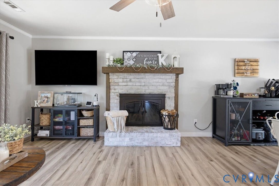 7900 Valencia Road, Chesterfield, VA 23832 Whitewashed brick fireplace with a wood mantle, wood-finish flooring, ceiling fan, and crown molding
