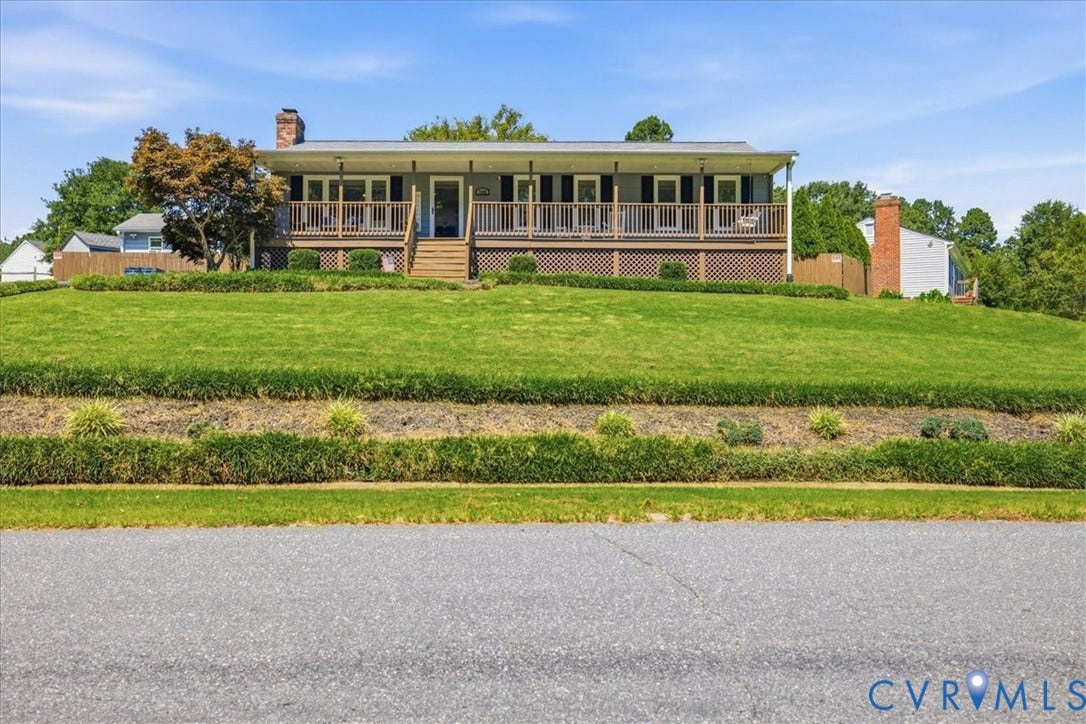 7900 Valencia Road, Chesterfield, VA 23832 Elevated ranch-style residence featuring a full-width covered porch, wood railing, and lattice skirting