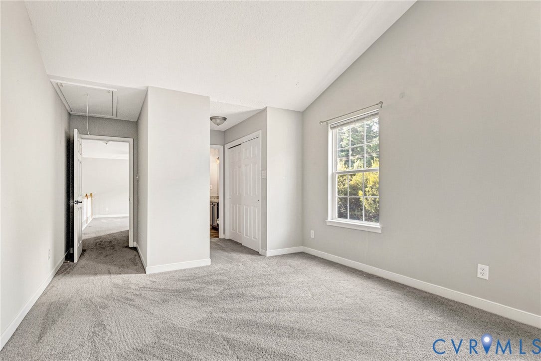 Vaulted ceiling, wall-to-wall carpeting, single hung window, and white trim throughout
