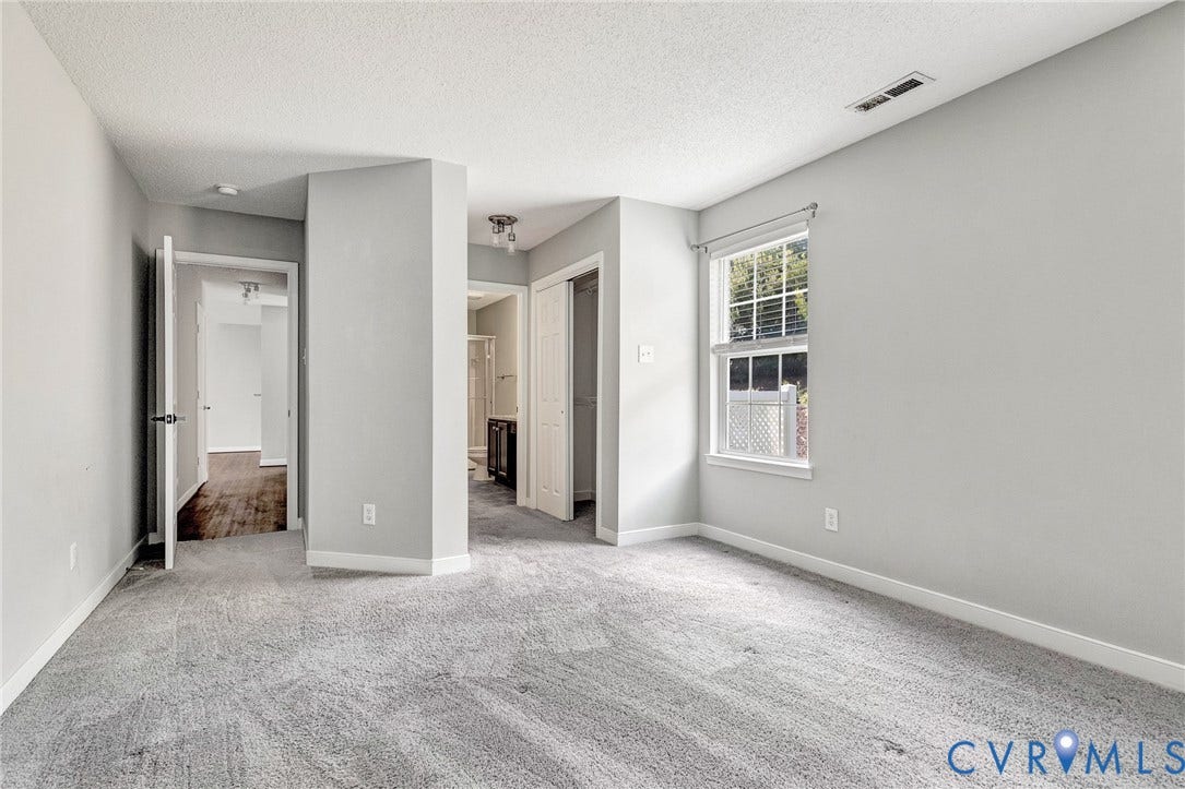 Wall-to-wall carpeting, multiple doorways, and a window with blinds
