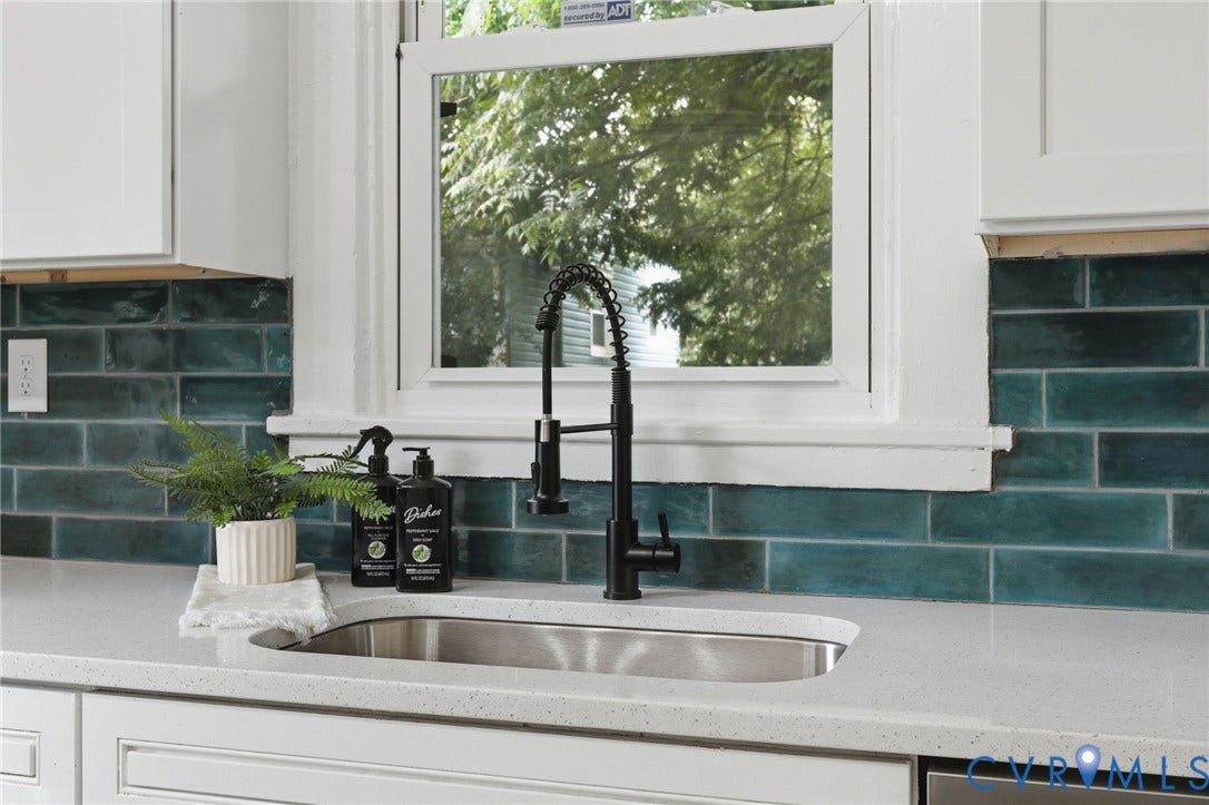 1815 Carlisle Avenue, Richmond, VA 23231 Under-mount stainless steel sink, black pull-down faucet, white upper cabinetry, white lower cabinetry, and green subway tile backsplash