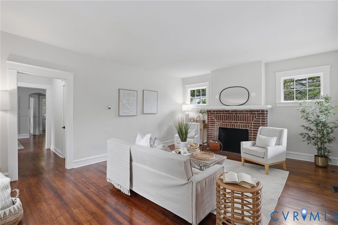1815 Carlisle Avenue, Richmond, VA 23231 Hardwood flooring extends throughout this space, featuring a brick fireplace with a white mantel and two windows with white trim