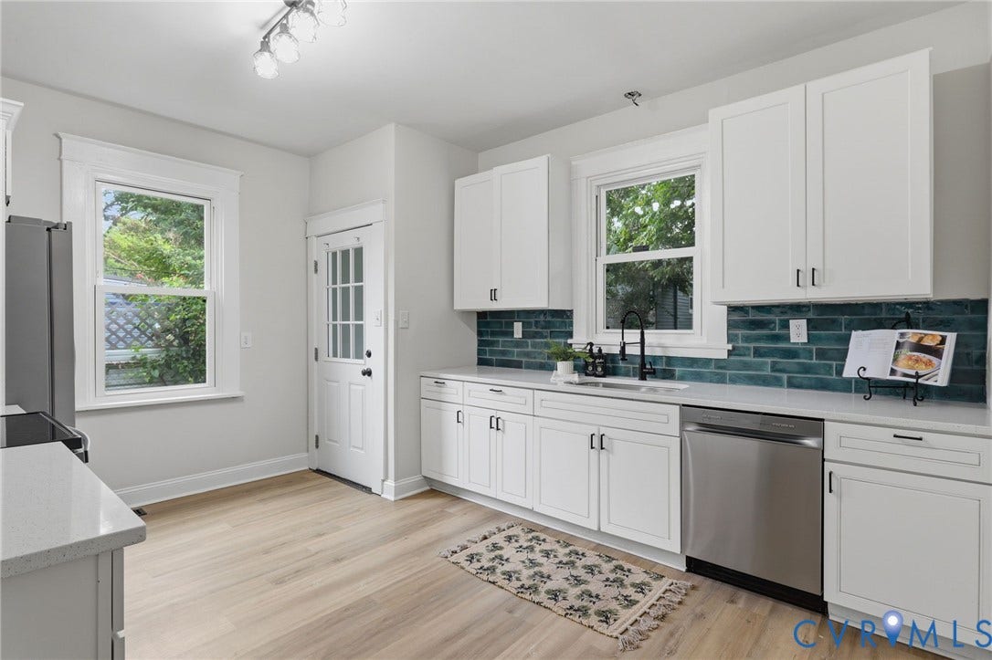 1815 Carlisle Avenue, Richmond, VA 23231 White shaker cabinetry, light wood-finish flooring, stainless steel dishwasher, white countertops, and a teal subway tile backsplash