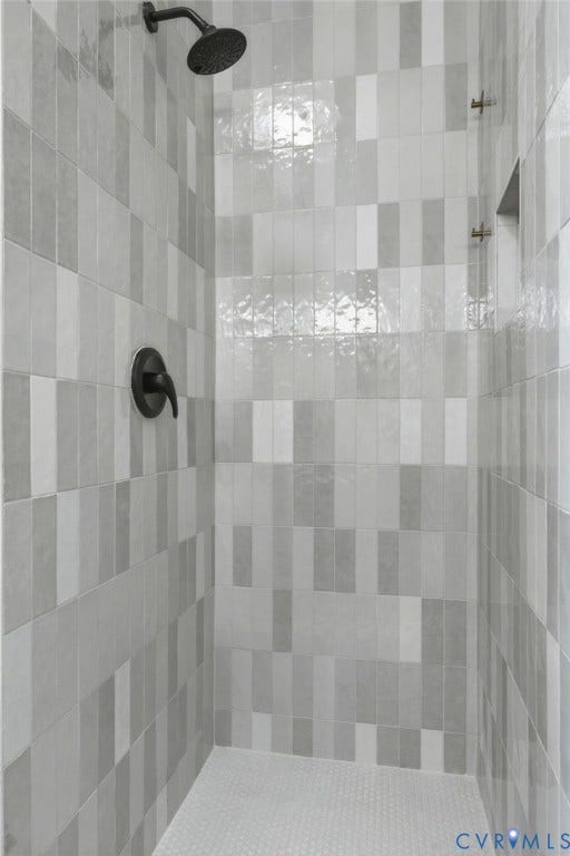 1815 Carlisle Avenue, Richmond, VA 23231 Vertical subway tile shower surround with varied gray tones, matte black shower head, matte black controls, and a built-in shower niche