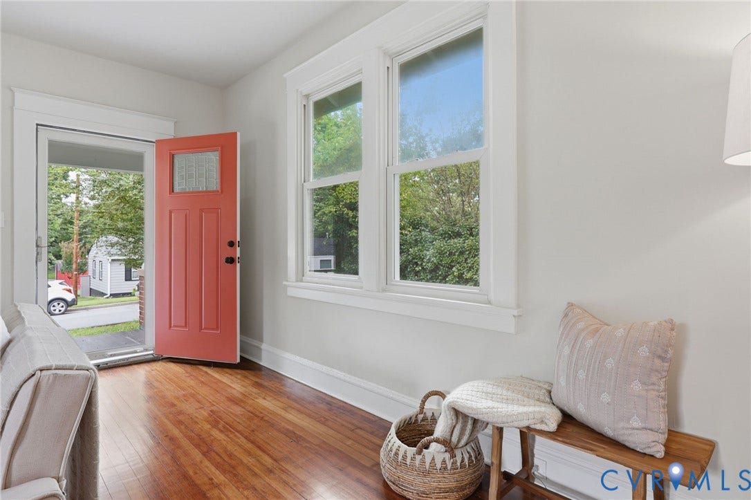 1815 Carlisle Avenue, Richmond, VA 23231 Hardwood flooring, white painted walls, large window with white trim, and a panel door with an upper glass insert