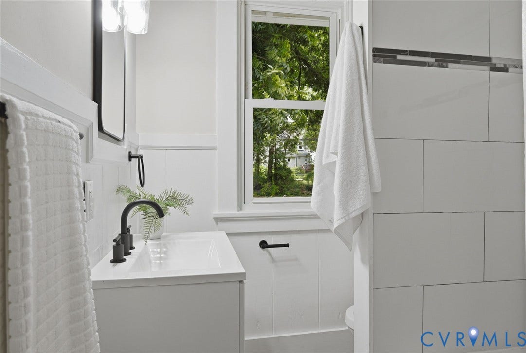 1815 Carlisle Avenue, Richmond, VA 23231 White paneled vanity with integrated sink, matte black faucet, and rectangular mirror