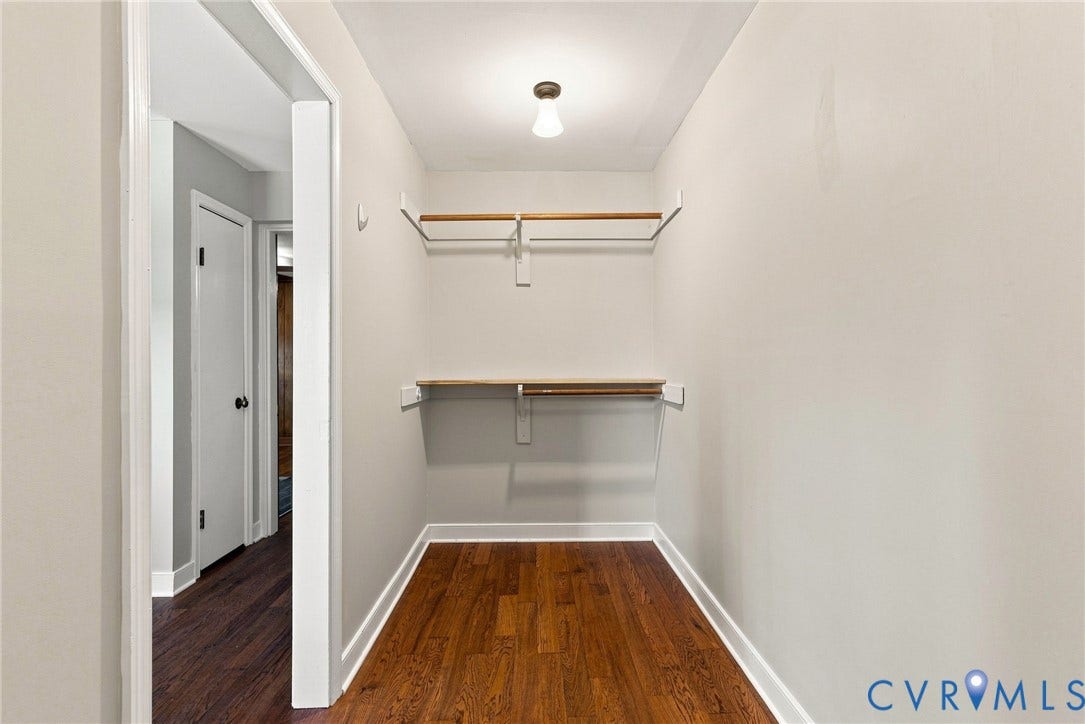 2707 Academy Road, Powhatan, VA 23139 Recessed closet featuring wood-finish flooring, light neutral wall paint, and two built-in storage rods with shelves