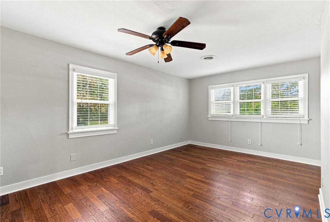 2707 Academy Road, Powhatan, VA 23139 Wood-finish flooring, white trim, a ceiling fan, and multiple windows with blinds