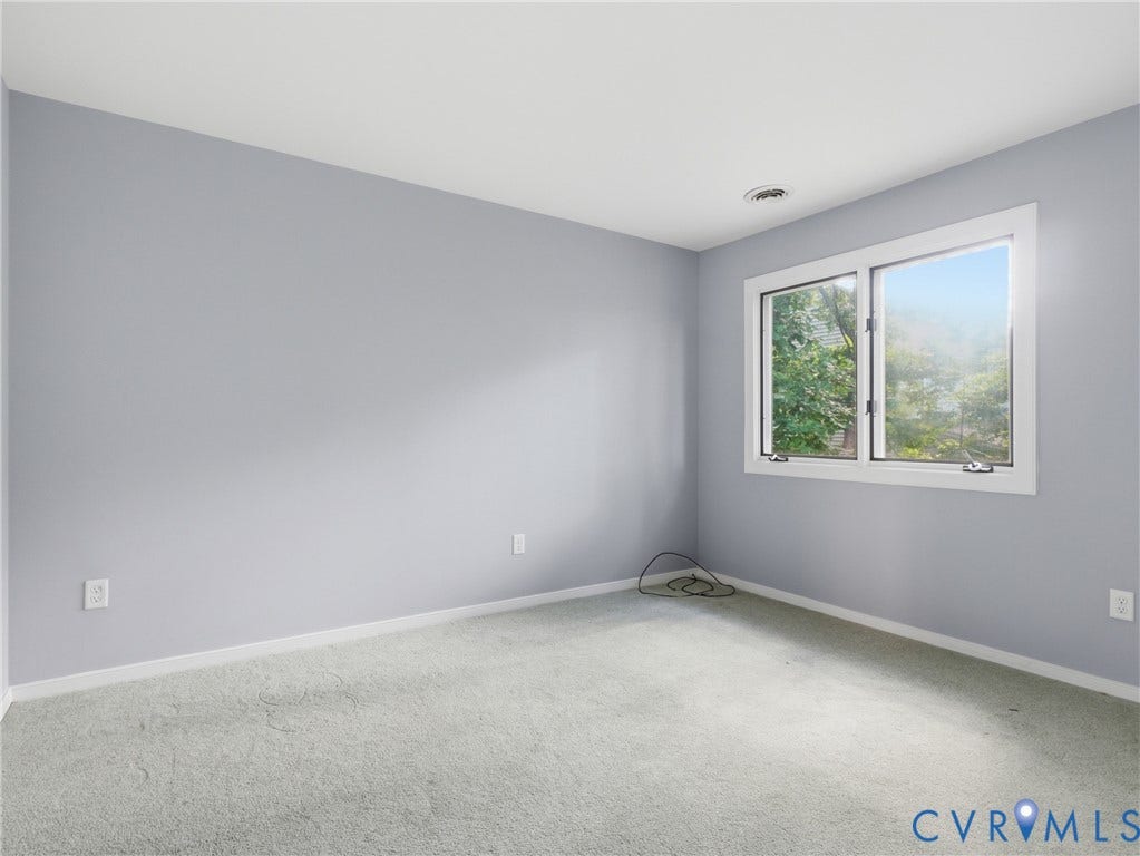 Wall-to-wall carpeting with light-toned walls and a white ceiling