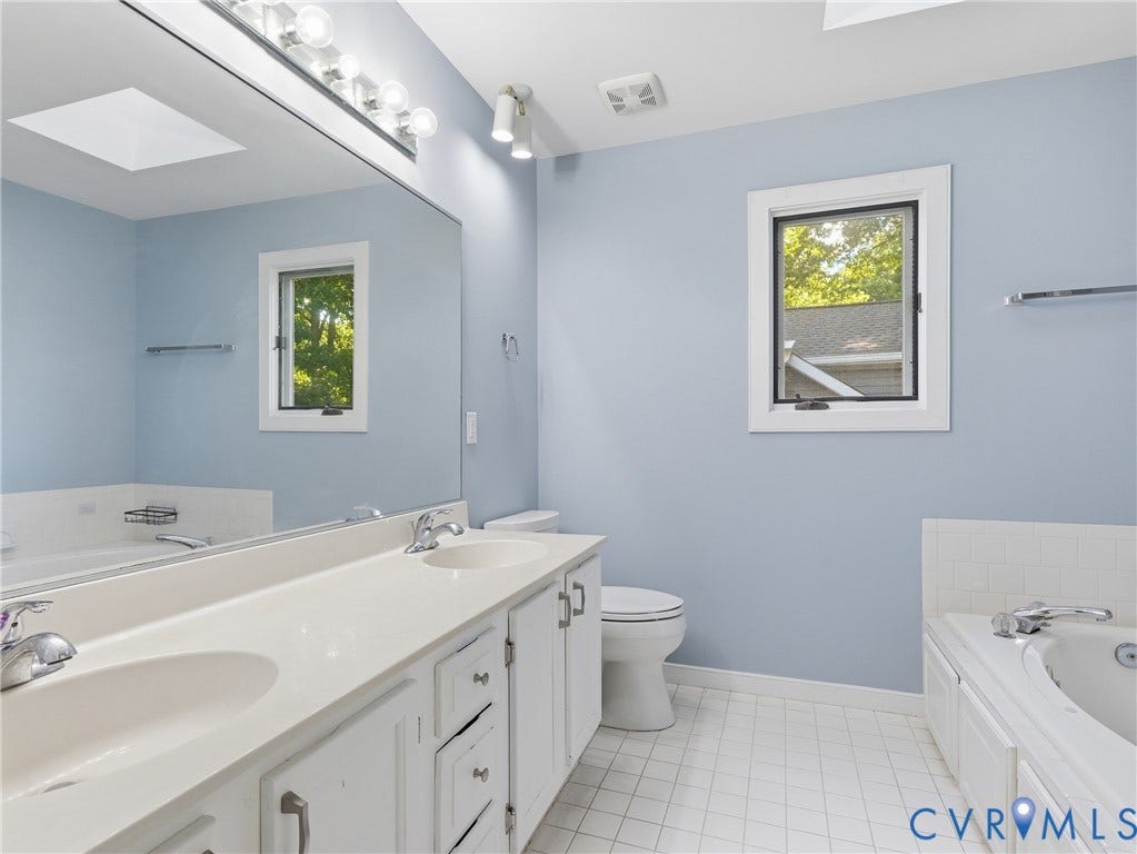 Dual vanity with integrated sinks, white cabinetry, and polished chrome fixtures