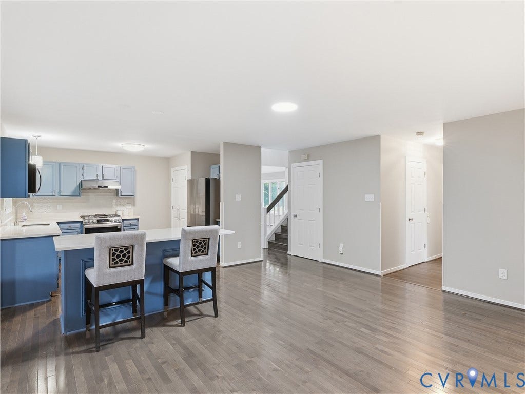 Kitchen featuring blue cabinetry, a white backsplash, and a center island with countertop seating