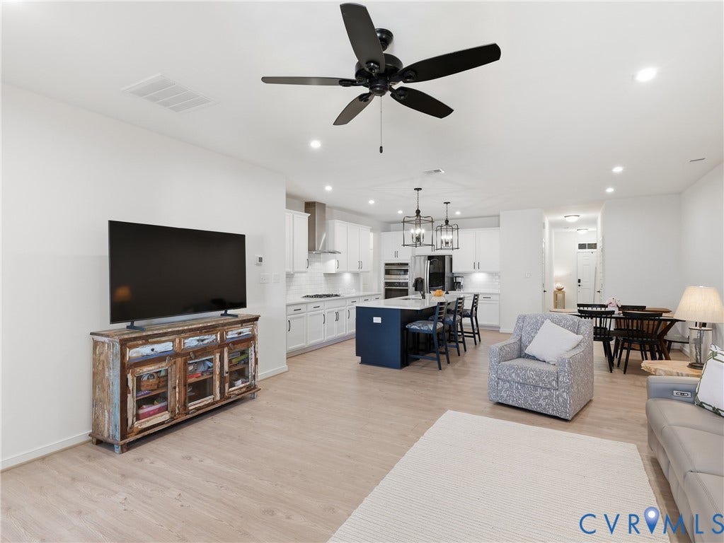 9220 Cerulean Place, Mosaic At West Creek, Goochland, VA 23238 Open-concept living space with light-tone wood-finish flooring, recessed lighting, and a ceiling fan