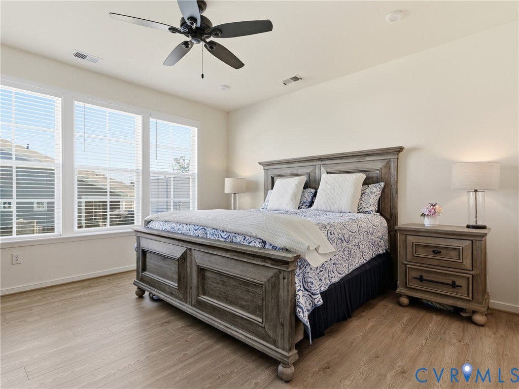 9220 Cerulean Place, Mosaic At West Creek, Goochland, VA 23238 Expansive room featuring multiple windows, wood-finish flooring, a ceiling fan with integrated lighting, and recessed ceiling lights