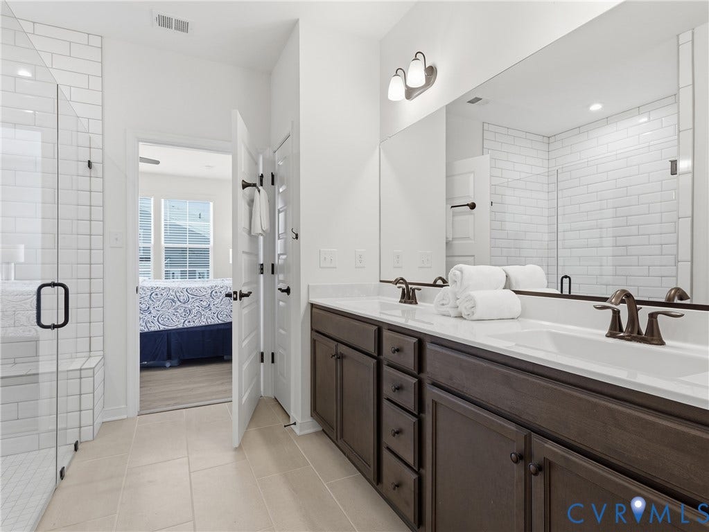 9220 Cerulean Place, Mosaic At West Creek, Goochland, VA 23238 Dual vanity with integrated sinks, dark wood-finish cabinetry, and brushed bronze fixtures