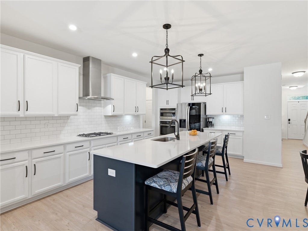 9220 Cerulean Place, Mosaic At West Creek, Goochland, VA 23238 Kitchen featuring white cabinetry, subway tile backsplash, stainless steel appliances, a center island with seating, and pendant lighting