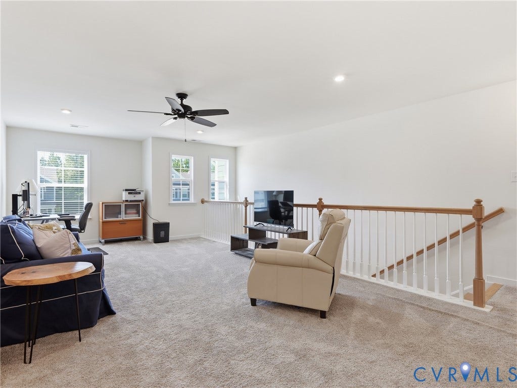 9220 Cerulean Place, Mosaic At West Creek, Goochland, VA 23238 Carpeted open loft with a ceiling fan, recessed lighting, multiple windows, and a wood and white spindle railing overlooking a staircase