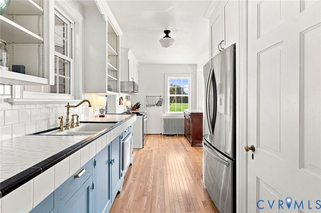 7134 Messer Road, Henrico, VA 23231 Kitchen featuring a stainless steel refrigerator, white subway tile backsplash, wood-finish flooring, and white cabinetry