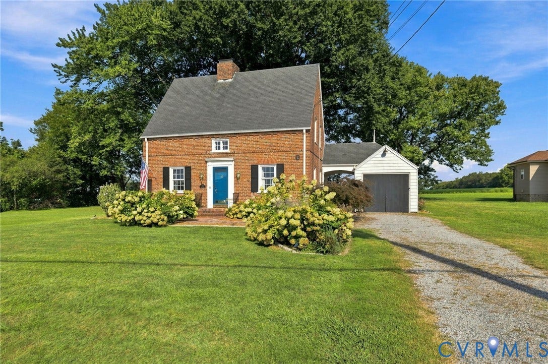 7134 Messer Road, Henrico, VA 23231 Brick exterior with dark shutters, a blue entry door, and a gravel driveway