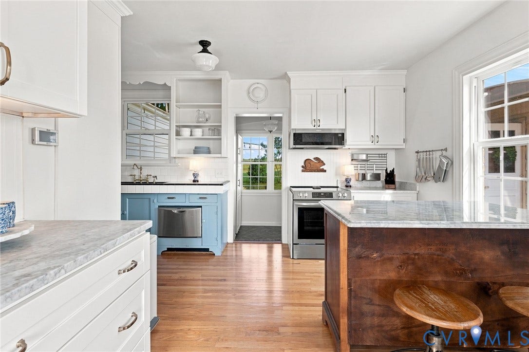7134 Messer Road, Henrico, VA 23231 Hardwood flooring, white cabinetry, a kitchen island with stone countertop, stainless steel appliances, and a built-in dishwasher