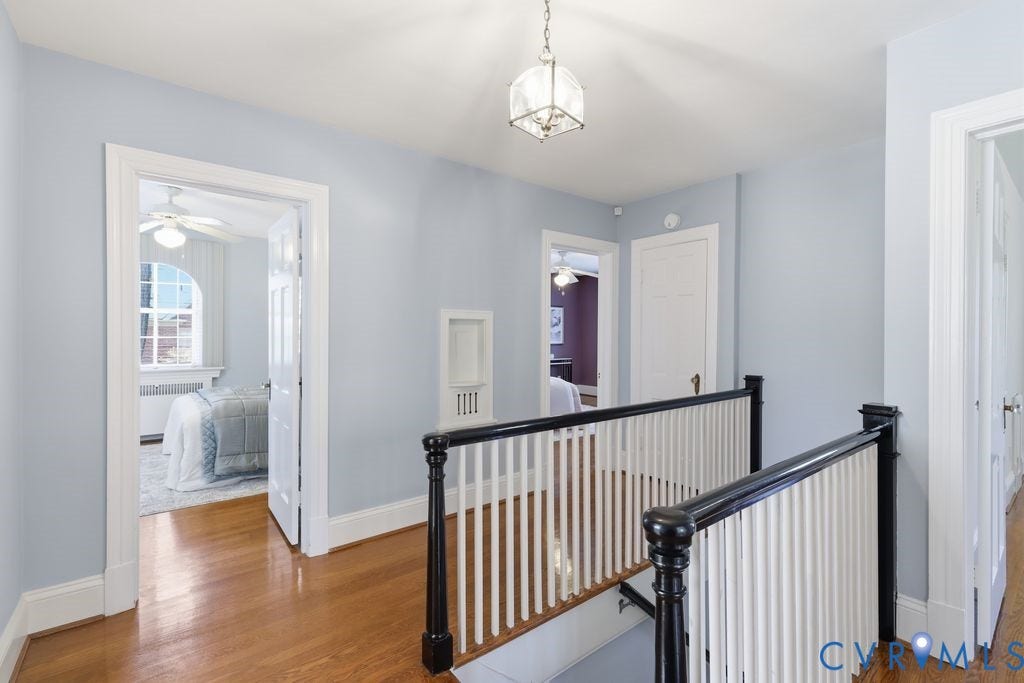 4117 W Franklin Street, Malvern Gardens, Richmond, VA 23221 Hardwood flooring, painted banister with white spindles, recessed wall niche, arched window, and ceiling fan