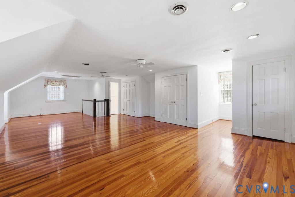 4117 W Franklin Street, Malvern Gardens, Richmond, VA 23221 Expansive room featuring hardwood flooring, multiple windows, a ceiling fan, recessed lighting, and a built-in closet with panel doors