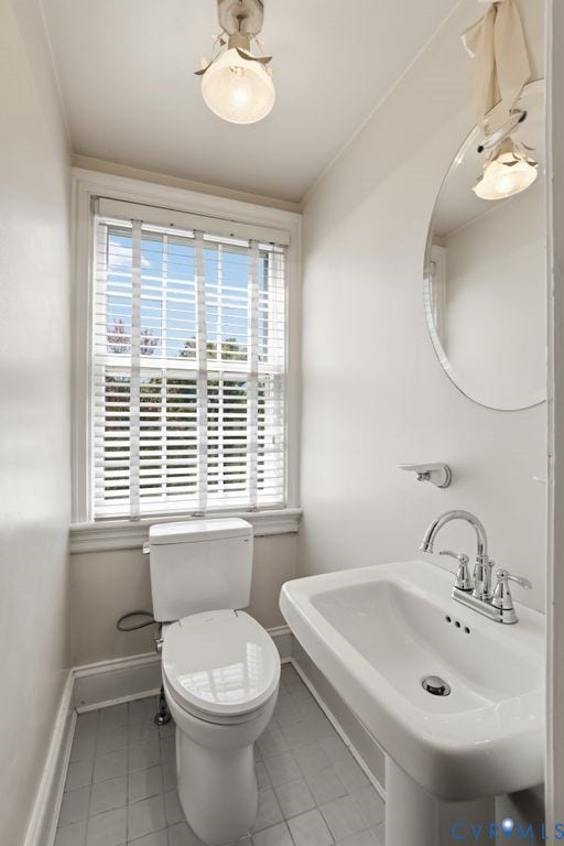 4117 W Franklin Street, Malvern Gardens, Richmond, VA 23221 Pedestal sink with chrome-finish faucet, window with white blinds, toilet, and ceiling-mounted light fixture