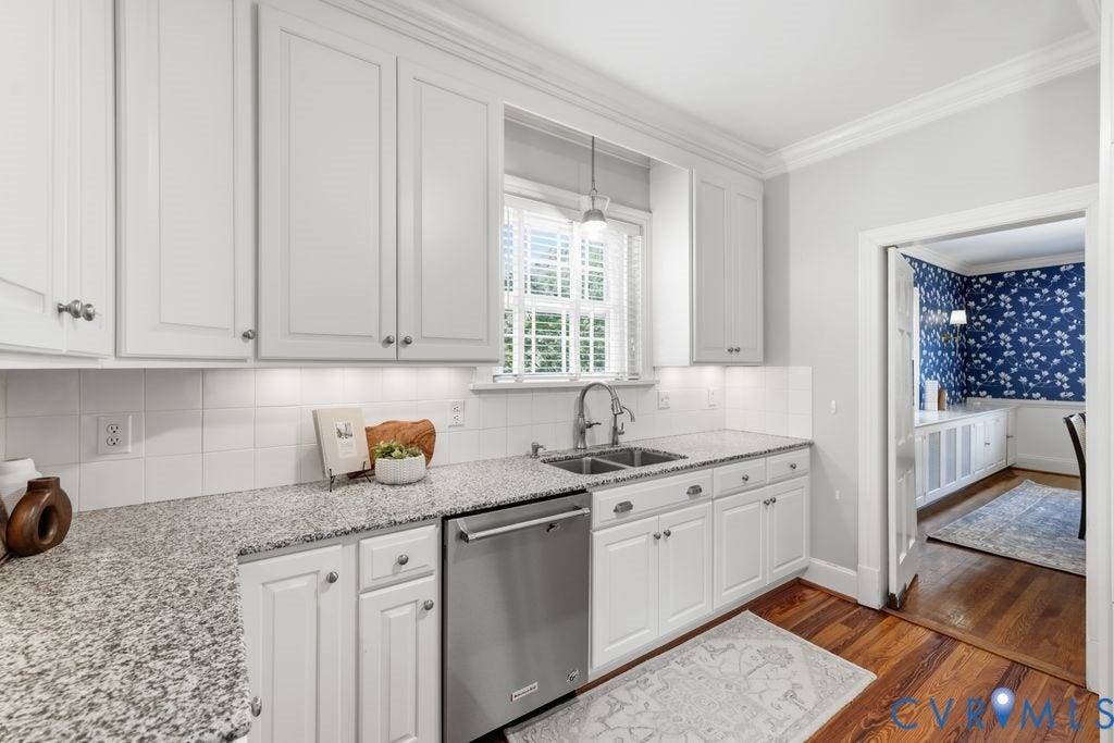 4117 W Franklin Street, Malvern Gardens, Richmond, VA 23221 White cabinetry with brushed nickel hardware, granite countertops, stainless steel dishwasher, tile backsplash, and wood-finish flooring