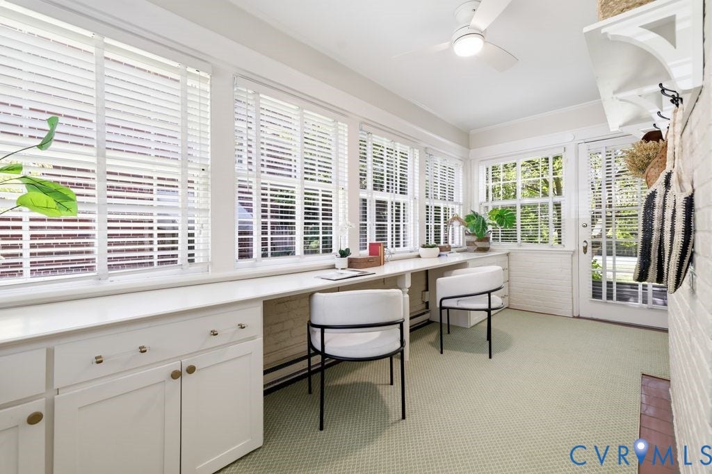 4117 W Franklin Street, Malvern Gardens, Richmond, VA 23221 White plantation shutters, built-in desk with storage, ceiling fan, and a white brick accent wall
