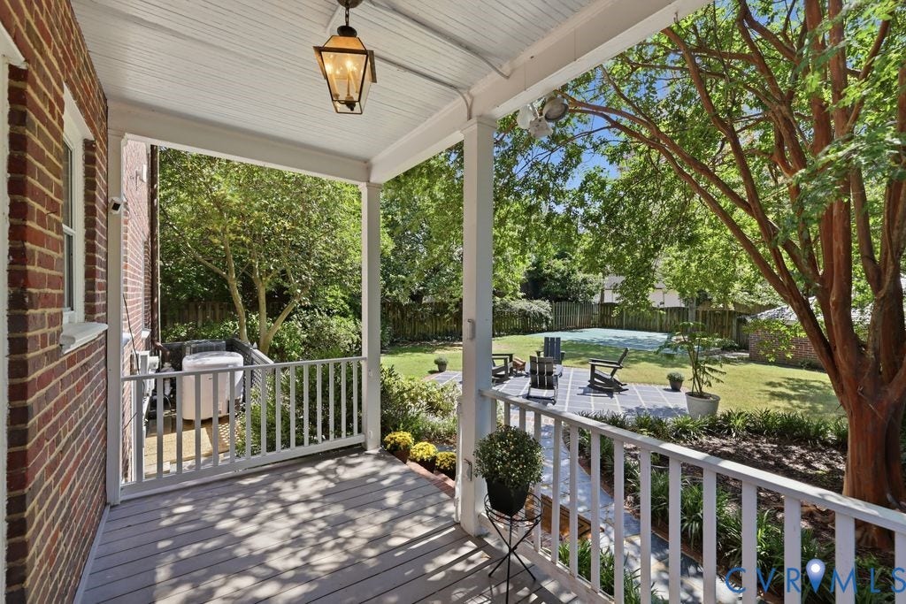 4117 W Franklin Street, Malvern Gardens, Richmond, VA 23221 Covered porch with wood-finish flooring and white railings, featuring a brick wall exterior