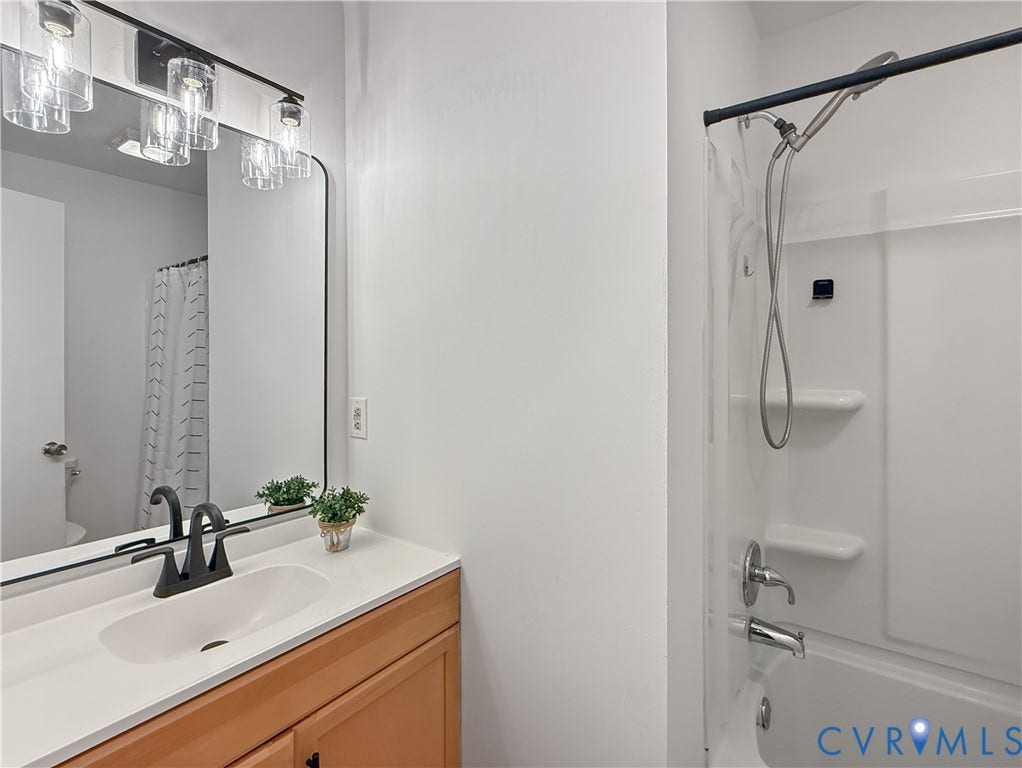 3203 Roland View Terrace, Chester, VA 23831 Integrated vanity with a single basin sink, matte black faucet, and wood-finish cabinetry