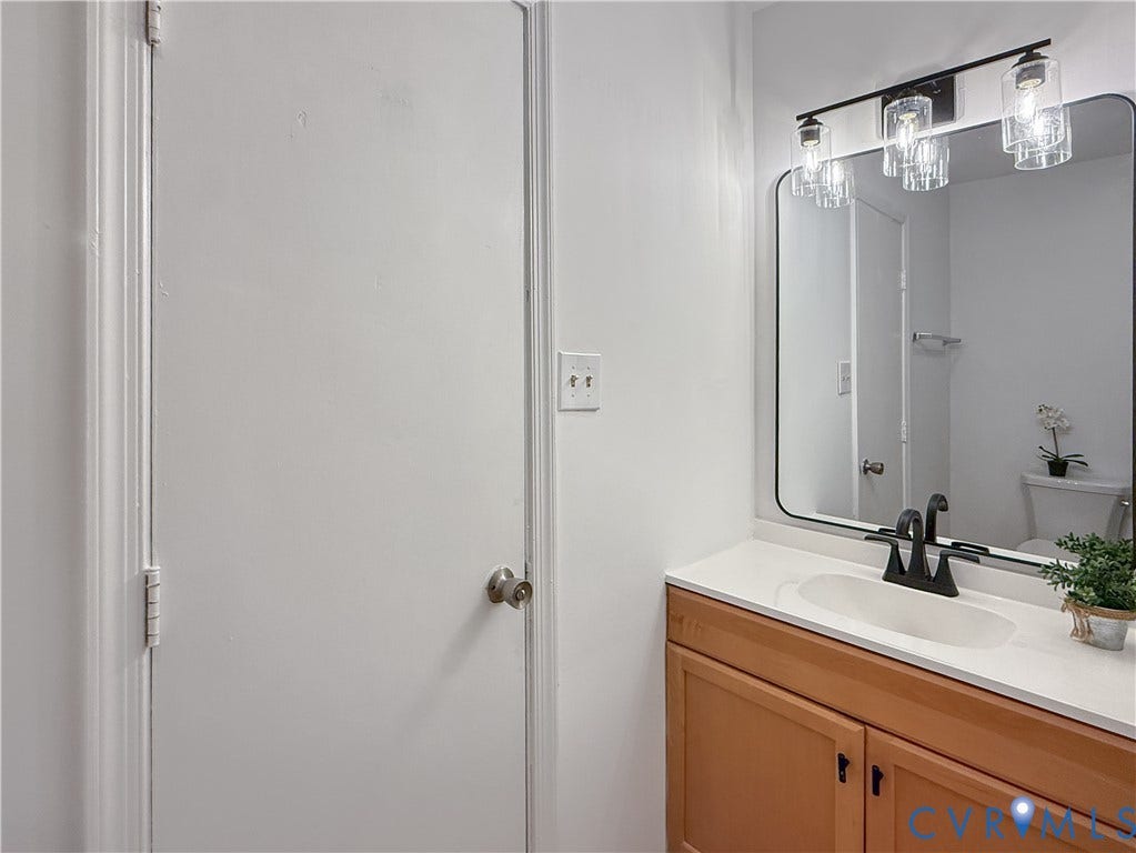 3203 Roland View Terrace, Chester, VA 23831 Wood-finish vanity with a white countertop and undermount sink