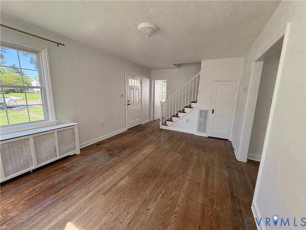 6211 Clover Lane, Lakeside, Henrico, VA 23228 Bright, open foyer featuring gleaming wood-finish flooring, abundant natural light from large front-facing windows, white painted walls, and a graceful staircase with white balusters and dark handrails leading to upper levels