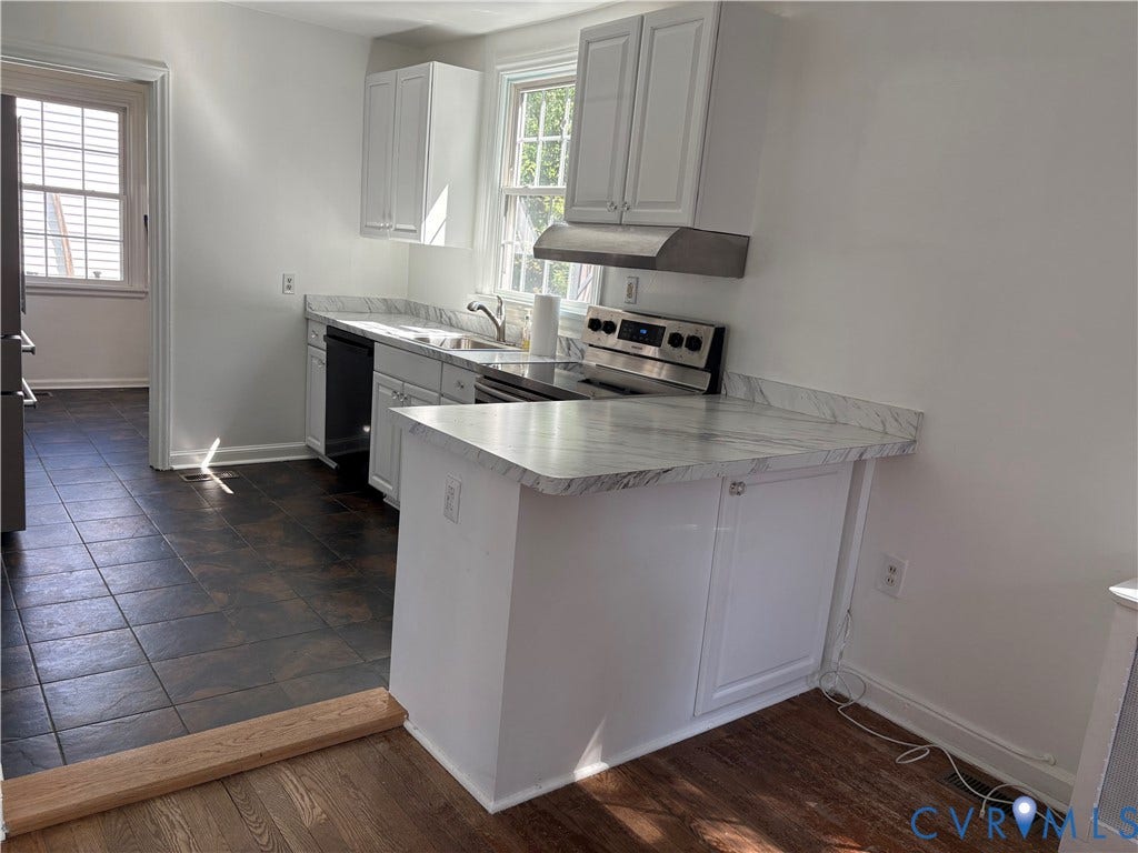 6211 Clover Lane, Lakeside, Henrico, VA 23228 Modern kitchen featuring white cabinetry with a marble-look quartz countertop island, stainless steel appliances including a range and hood vent, and abundant natural light from multiple windows