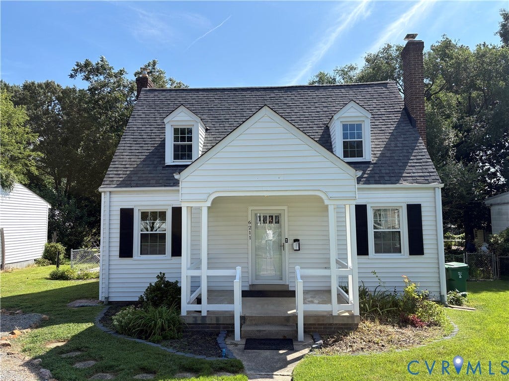 6211 Clover Lane, Lakeside, Henrico, VA 23228 White siding exterior with a dark shingle roof, featuring a brick chimney and two dormer windows