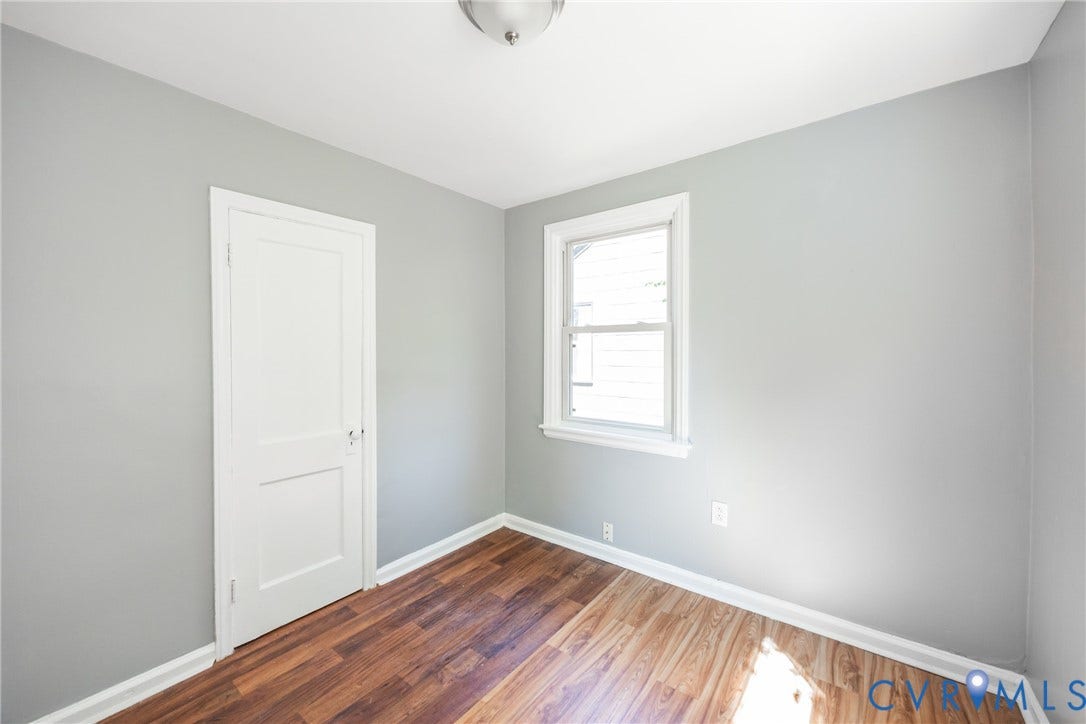 3505 Meadowbridge Road, Richmond, VA 23222 Wood-finish flooring, light gray wall paint, white trim, white paneled door, and a single window