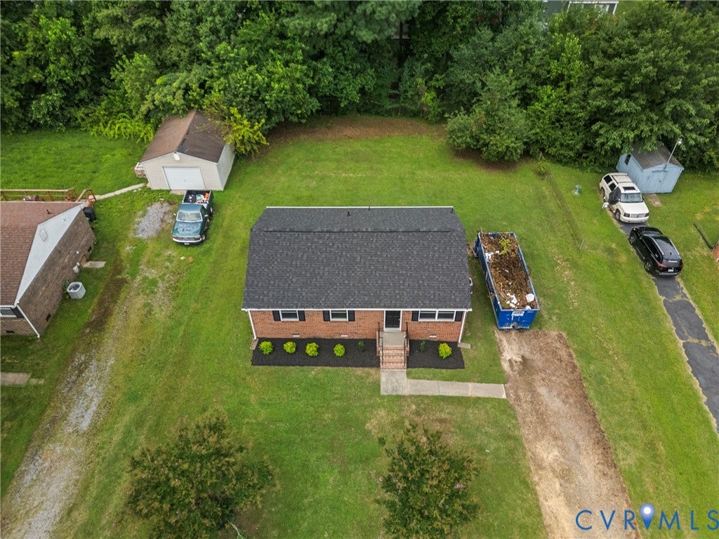 3924 Lamplighter Drive, Richmond, VA 23234 Brick facade home with a black shingle roof, featuring a concrete walkway, mature landscaping, and a detached storage shed