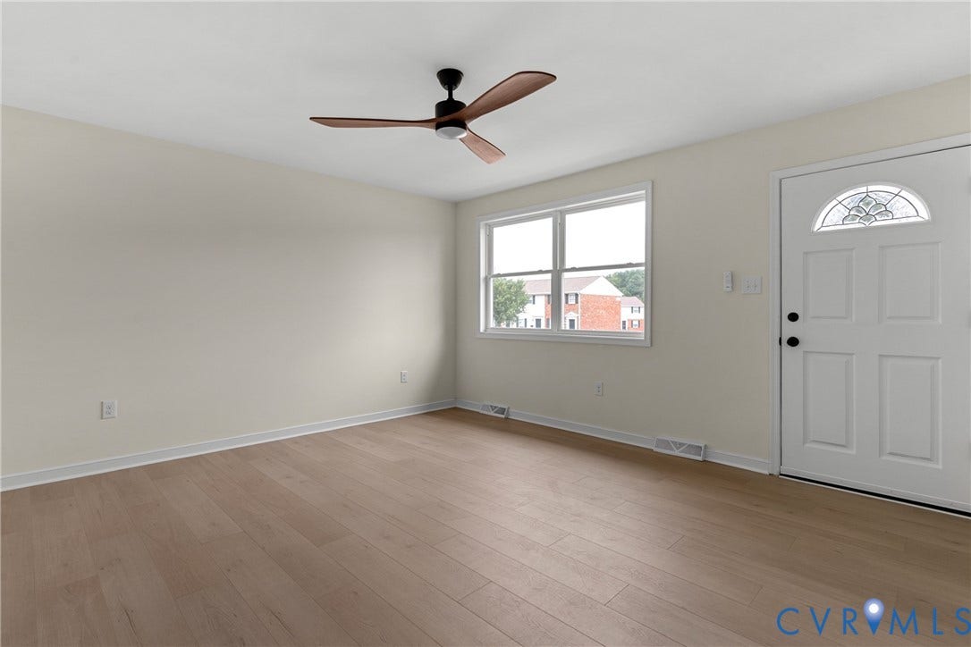 3924 Lamplighter Drive, Richmond, VA 23234 Bright living space featuring wood-finish flooring, a contemporary ceiling fan with wooden blades, and neutral painted walls