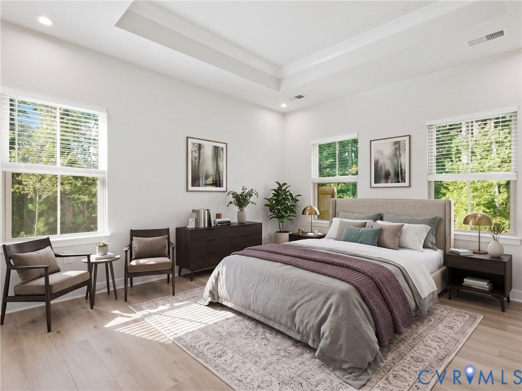 First-floor primary bedroom with tray ceiling and wooded views [Virtually staged for visualization purposes; actual room is unfurnished.]