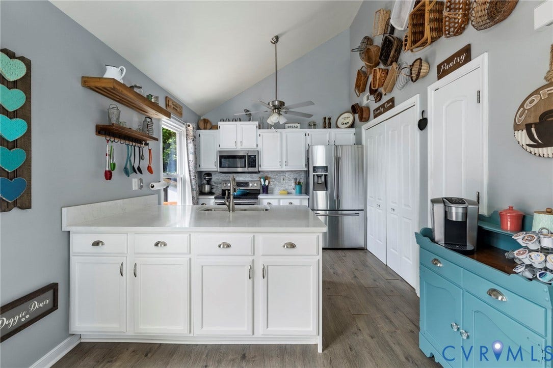 10138 Alberta Circle, Chesterfield, VA 23832 Kitchen featuring vaulted ceilings, white cabinetry, stainless steel appliances, a center island with countertop, and wood-finish flooring