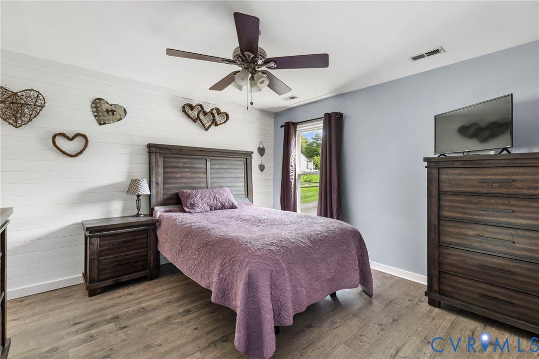 10138 Alberta Circle, Chesterfield, VA 23832 Wood-finish flooring with a textured accent wall, ceiling fan, and window with curtains