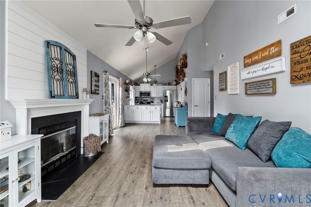 10138 Alberta Circle, Chesterfield, VA 23832 Vaulted ceilings, wood-finish flooring, white shiplap accent wall, fireplace with white mantel, and ceiling fans