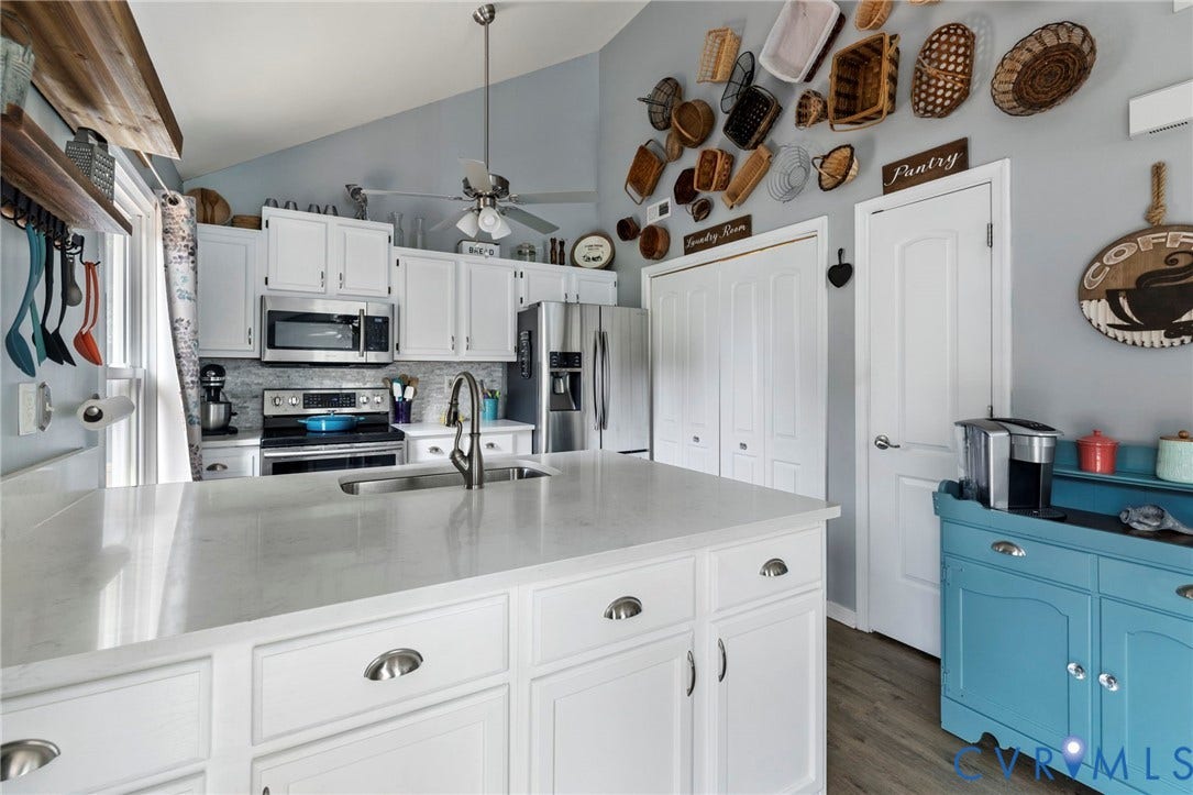 10138 Alberta Circle, Chesterfield, VA 23832 Kitchen featuring white cabinetry, stainless steel appliances, a large island with an undermount sink, and vaulted ceilings