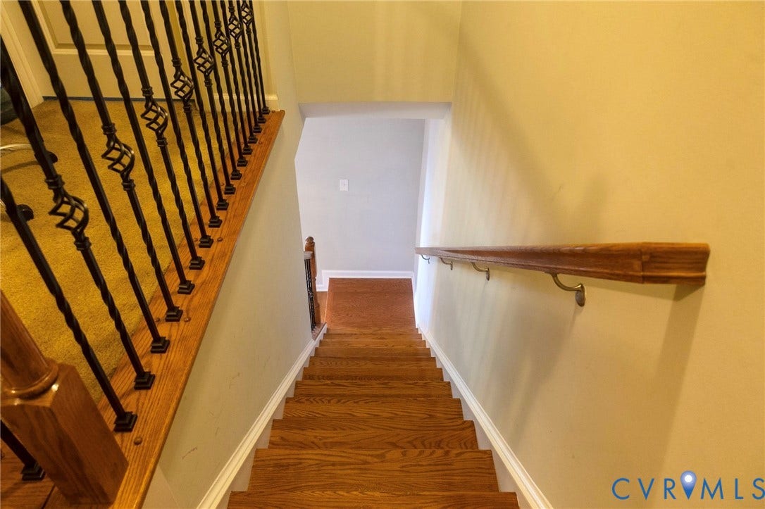 11617 Vicars Ridge Lane, Glen Allen, VA 23059 Staircase featuring wood-finish treads, a contrasting wood-finish handrail, and wrought iron balusters with decorative elements